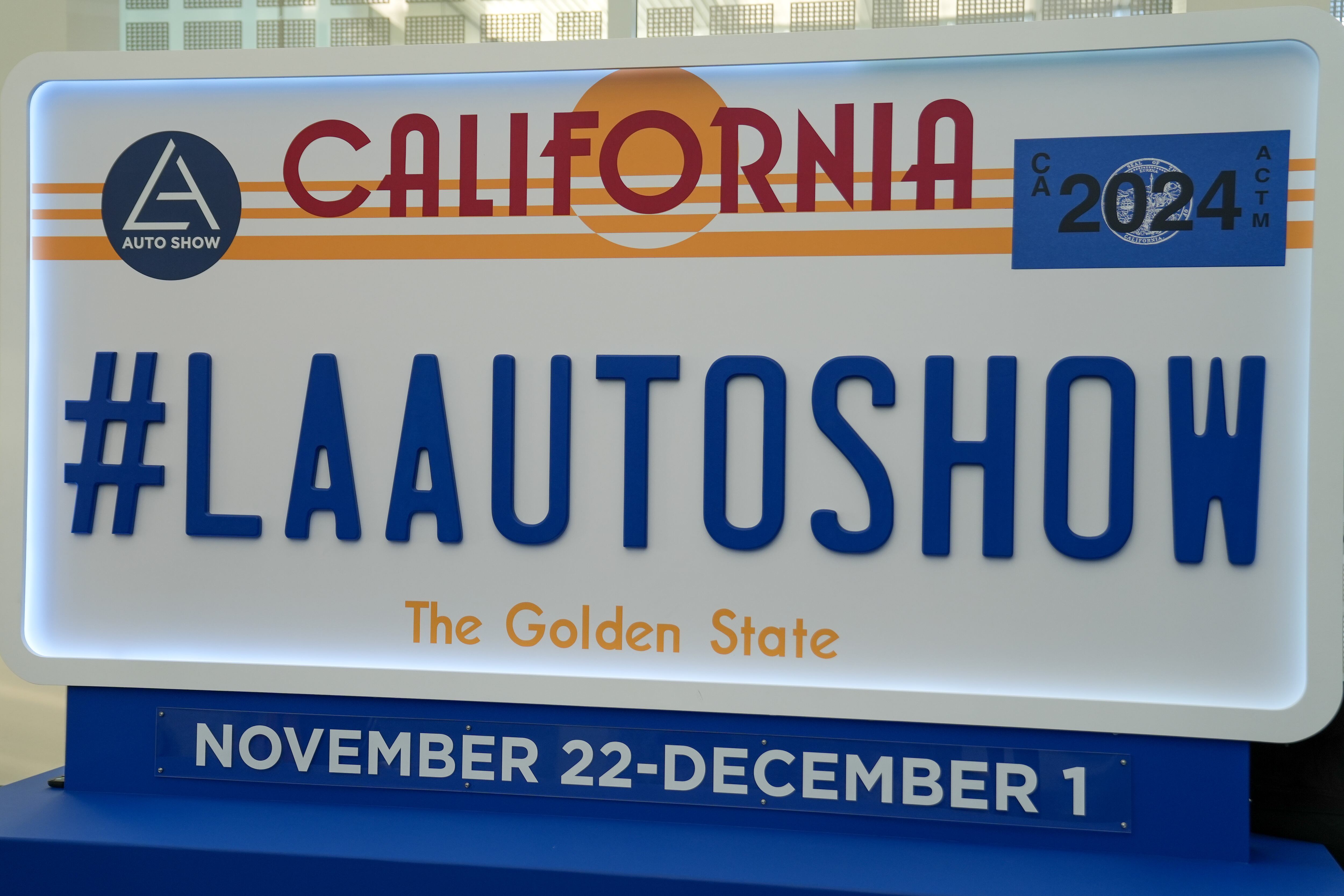 A large sign in the shape of a license plate advertising the Los Angeles Auto Show.