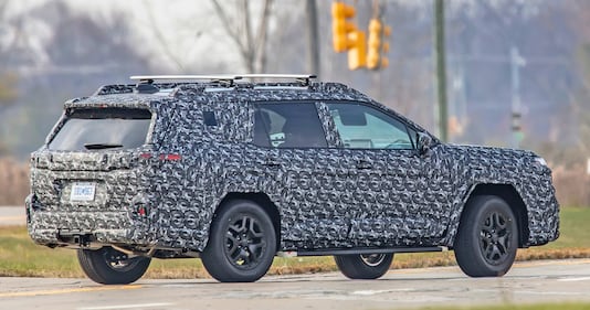 Side view of a camouflaged Subaru Outback test vehicle