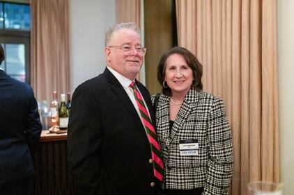 A man and woman stand next to each other during a cocktail party at an awards event.