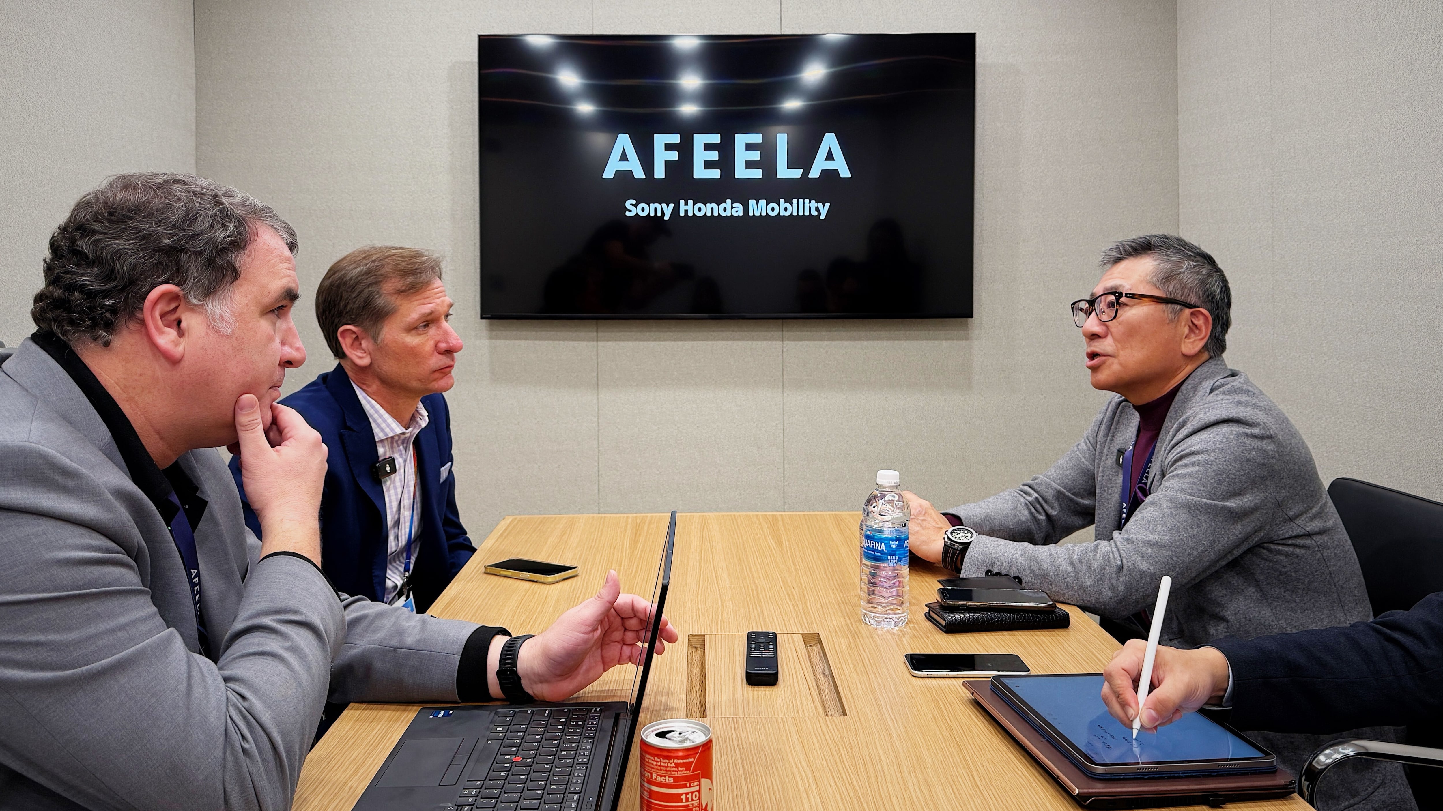 Three men around a table doing a media interview