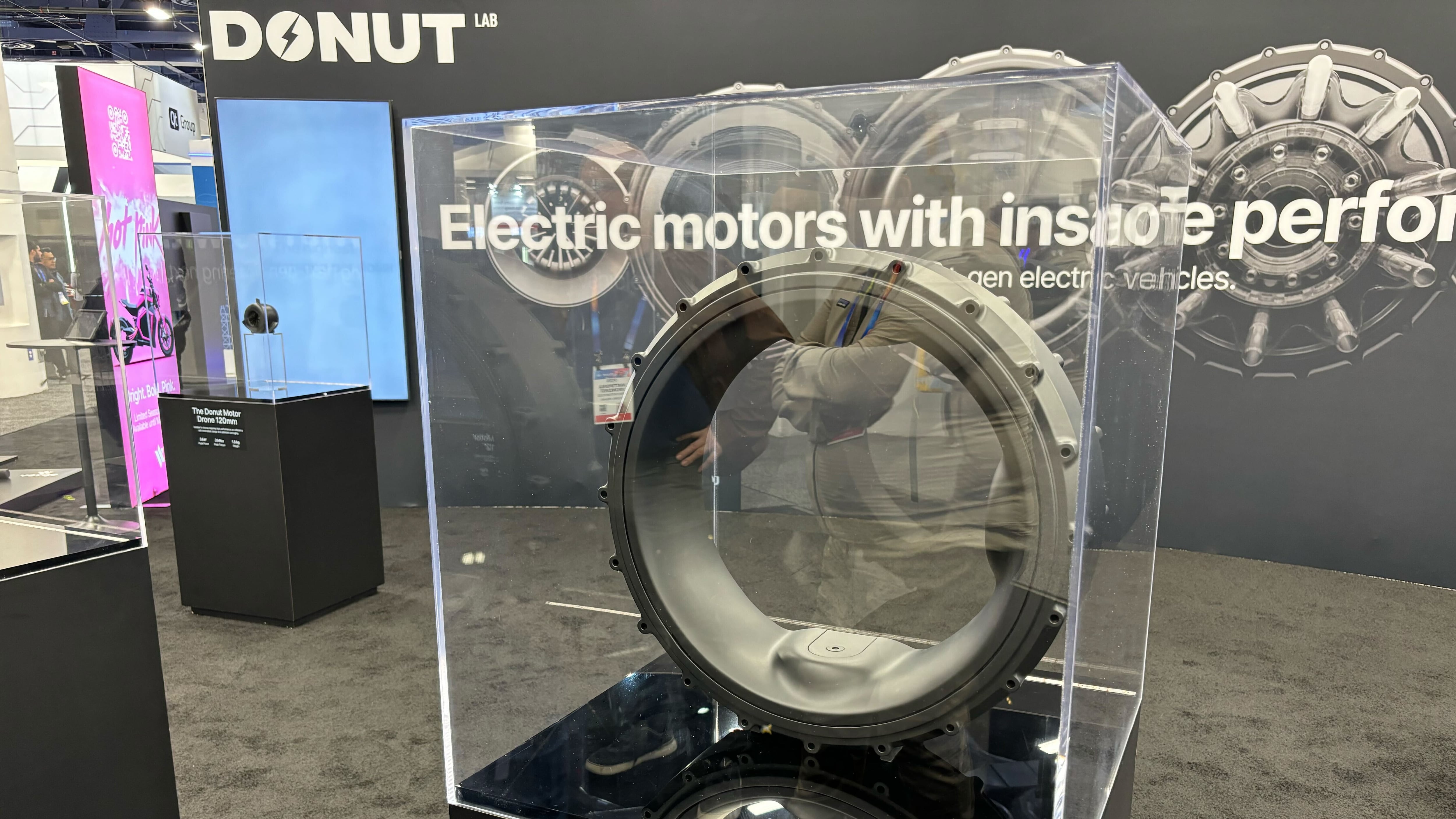 An electric wheel motor on a stand display at a technology show.