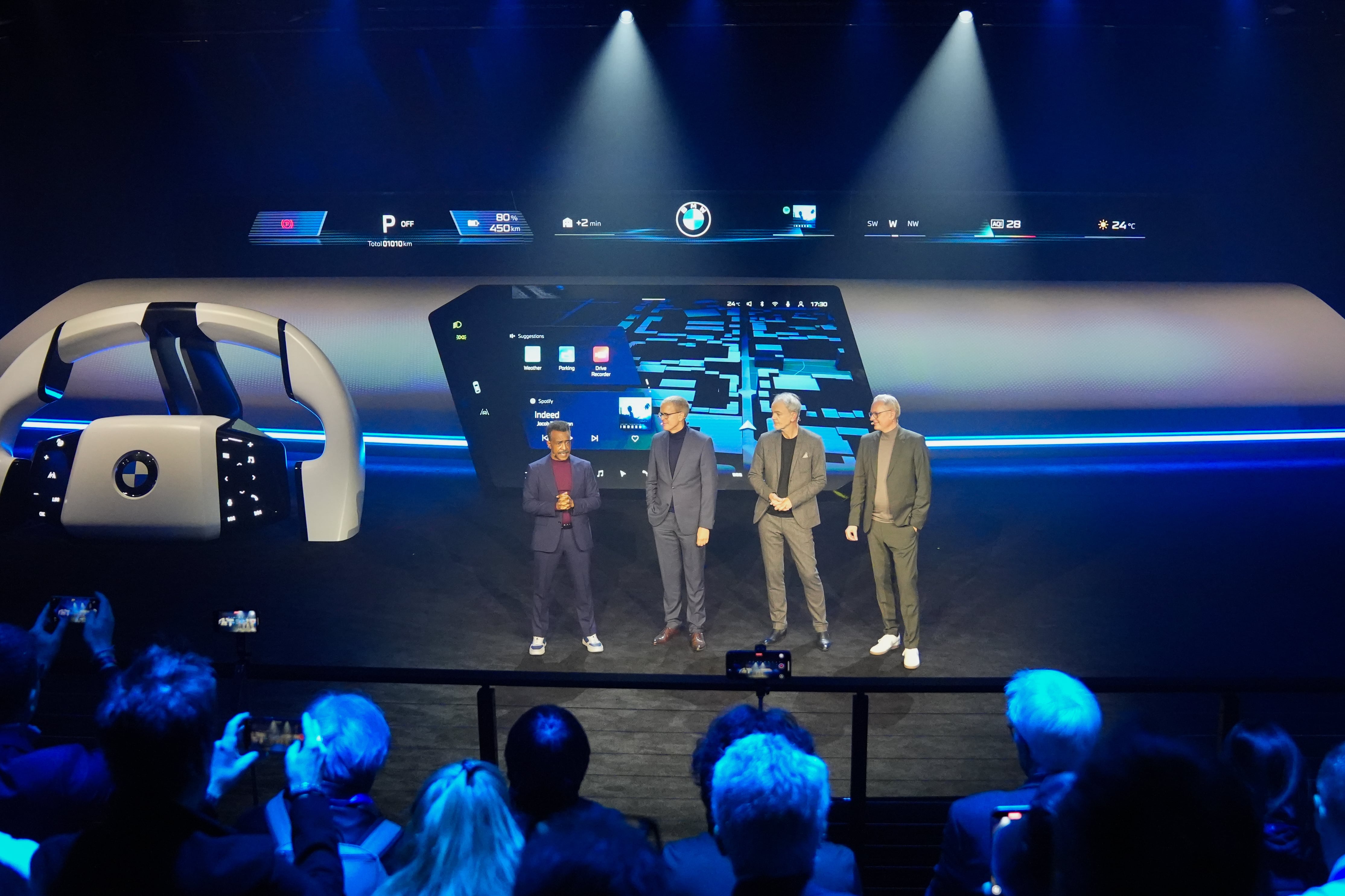 A group of men in business casual wear onstage at an automotive showcase event.