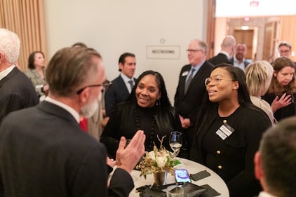 A crowd of people converse with each other during a cocktail hour before an awards event.