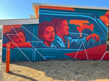 A mural of a family cruising in a classic car is painted on the side of Ionna's Apex, N.C., charging station.